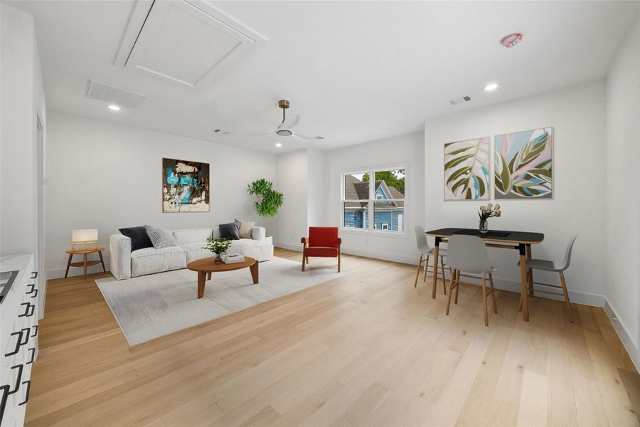 Designed with versatility in mind, the garage apartment features an open-concept layout with recessed lighting, modern ceiling fan, and multiple furniture configuration options. Positioned above the detached garage, the space creates separation from the main residence while maintaining connection to the property. Kitchenette shown is digitally staged for visual reference only. (digitally staged)