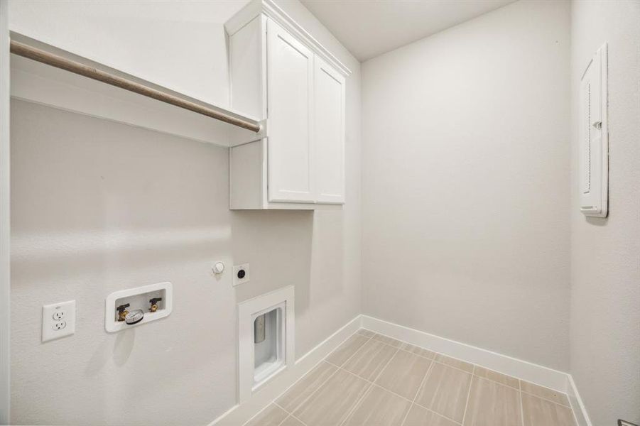 Laundry room with gas dryer hookup, cabinets, hookup for a washing machine, hookup for an electric dryer, and light tile patterned flooring