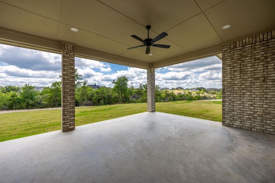 Expansive covered patio featuring a concrete slab, recessed lighting, and a ceiling fan