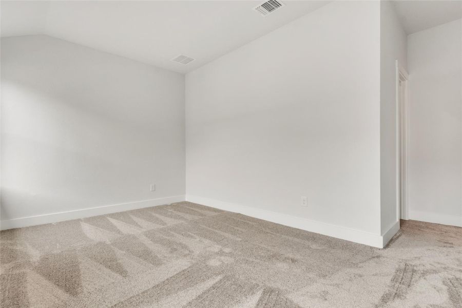 An inviting secondary bedroom offers ample space and plush carpeting, ready for personalization.