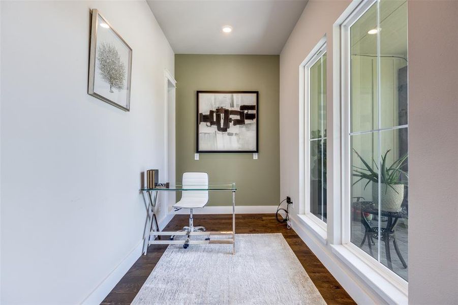 Home office with dark wood-style floors and recessed lighting