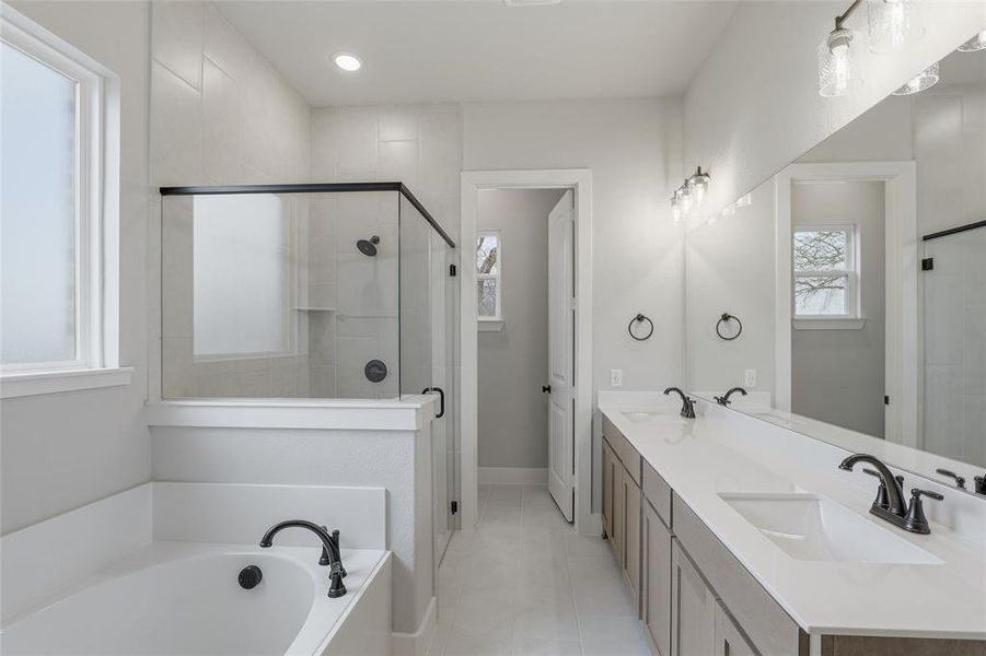 Bathroom with double vanity, a shower stall, a garden tub, light tile patterned floors, and recessed lighting