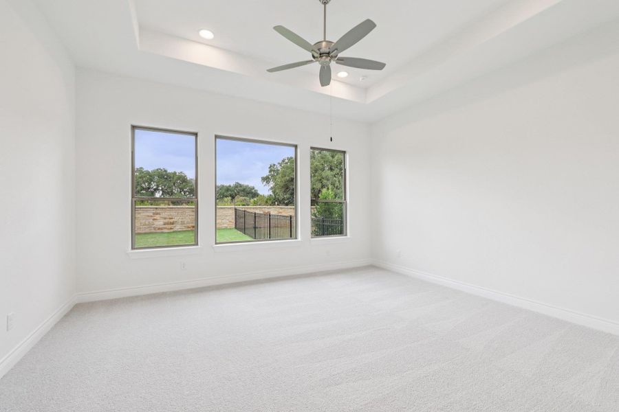Unfurnished room with light colored carpet, a tray ceiling, recessed lighting, and ceiling fan