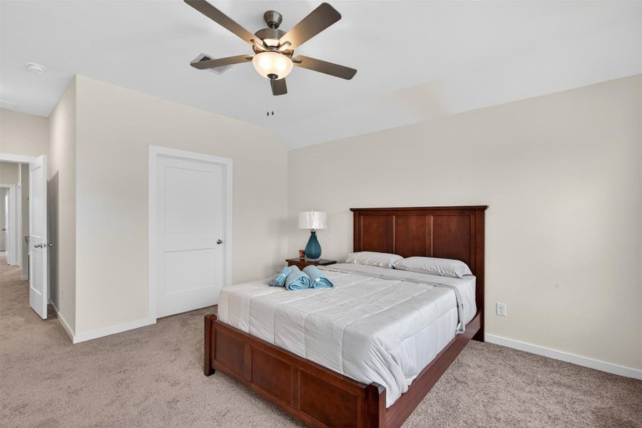Spacious primary suite featuring vaulted ceilings, plush carpeting, and a calming neutral palette that creates a serene retreat. Spacious primary suite featuring vaulted ceilings, plush carpeting, and a calming neutral palette that creates a serene retreat.