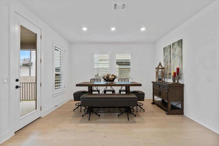 Dining room with light wood-style flooring, healthy amount of natural light, and recessed lighting