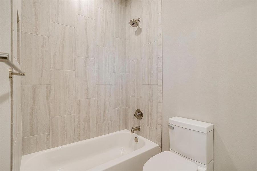 Bathroom featuring shower / bathtub combination and toilet