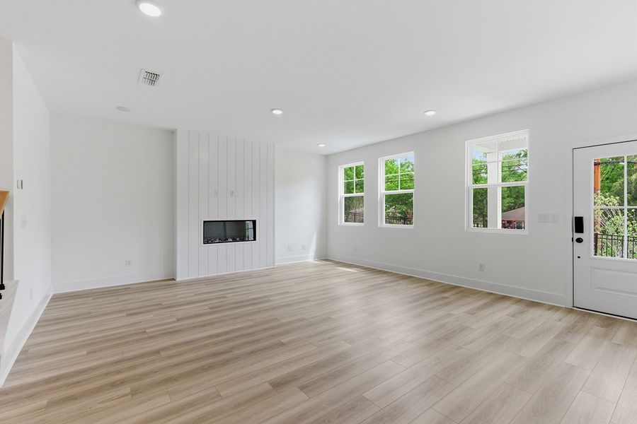 A large empty room with a wood floor and white walls. A large empty room with a wood floor and white walls.