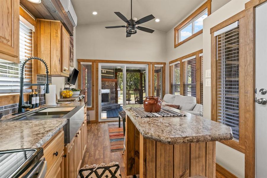 Kitchen featuring dark wood-style floors, open floor plan, a high ceiling, stainless steel range with electric stovetop, and a center island