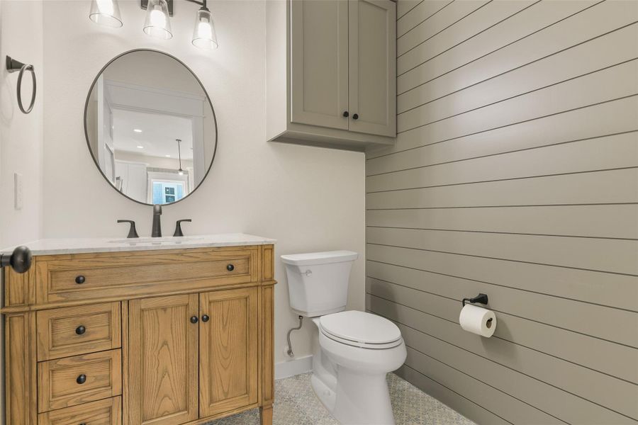 Charming third-floor half bath featuring stylish shiplap walls, seamlessly blending elegance with convenience. Charming third-floor half bath featuring stylish shiplap walls, seamlessly blending elegance with convenience.