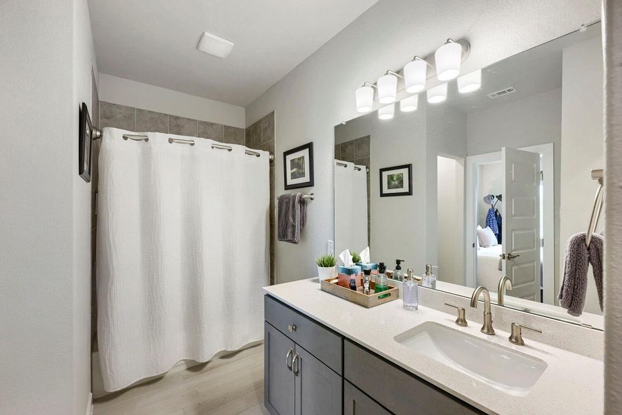 A well-appointed bathroom features a modern vanity with a wide sink and bright overhead lighting. A well-appointed bathroom features a modern vanity with a wide sink and bright overhead lighting.