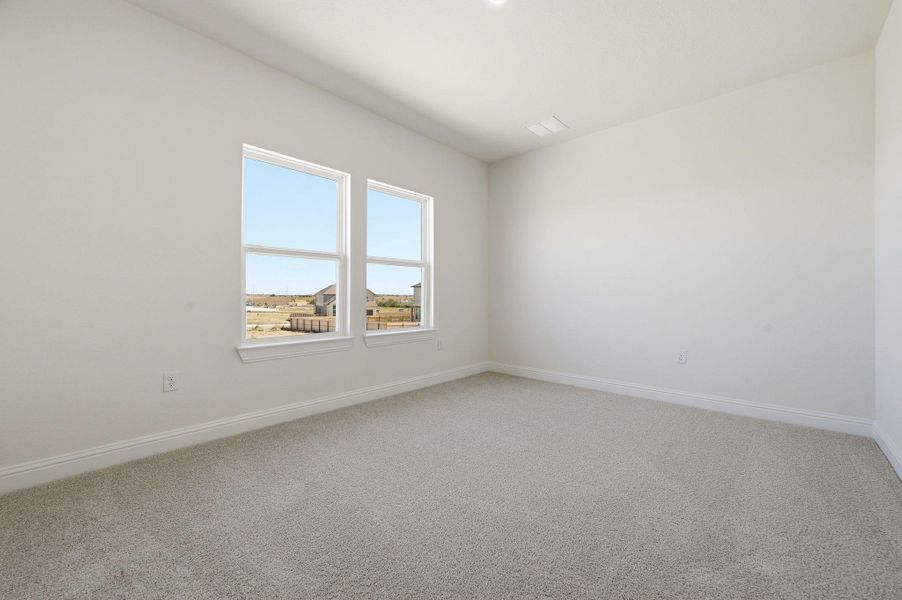 Empty room featuring light carpet and baseboards