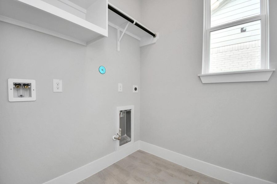 A perfect blend of functionality and comfort. Capture the essence of easy living with a first-floor laundry room, thoughtfully equipped with shelving for effortless organization. Both electric and gas connections available. Sample photo of completed home with similar floor plan. Actual colors and selections may vary. A perfect blend of functionality and comfort. Capture the essence of easy living with a first-floor laundry room, thoughtfully equipped with shelving for effortless organization. Both electric and gas connections available. Sample photo of completed home with similar floor plan. Actual colors and selections may vary.