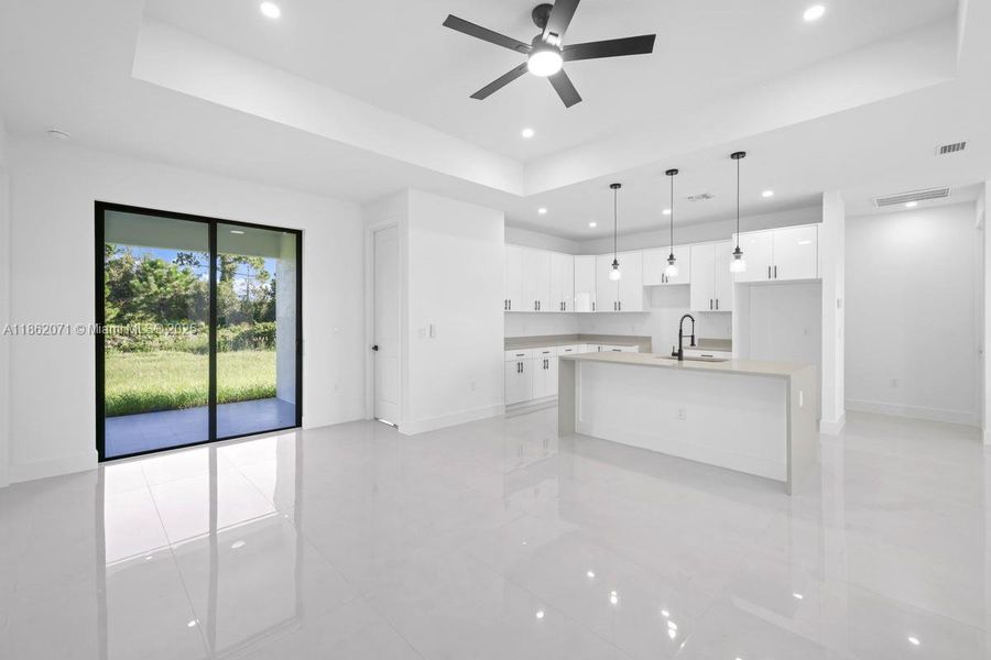 ACTUAL OPEN LIVING AREA LOOKING TO KITCHEN AND OUTSIDE LANAI