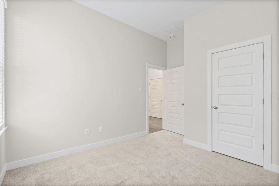 Light-toned wall paint, white trim, and light-toned carpeting
