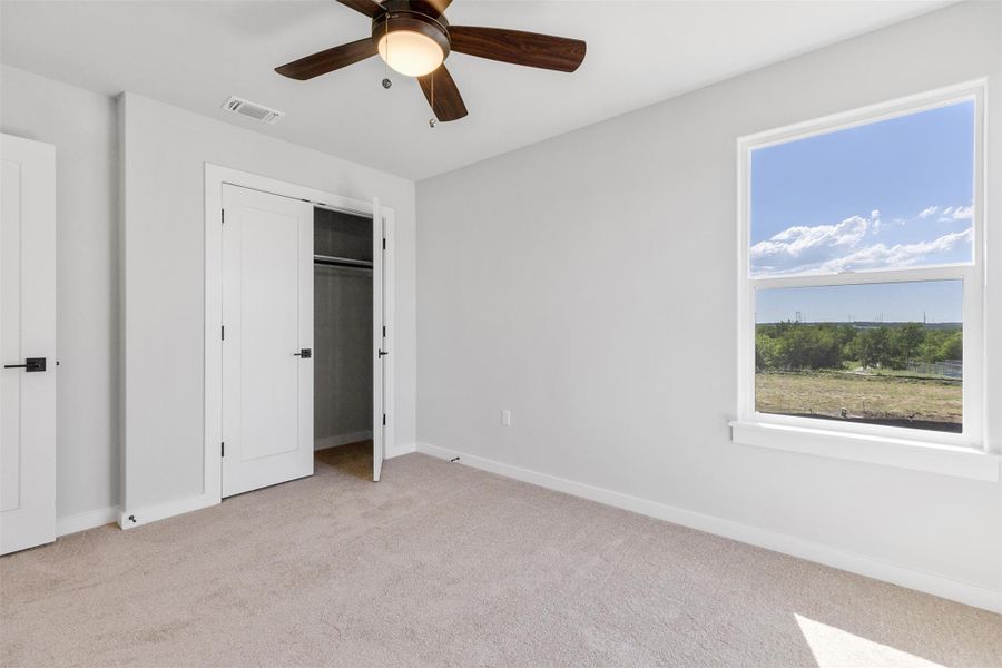 Unfurnished bedroom with light colored carpet, a closet, and ceiling fan