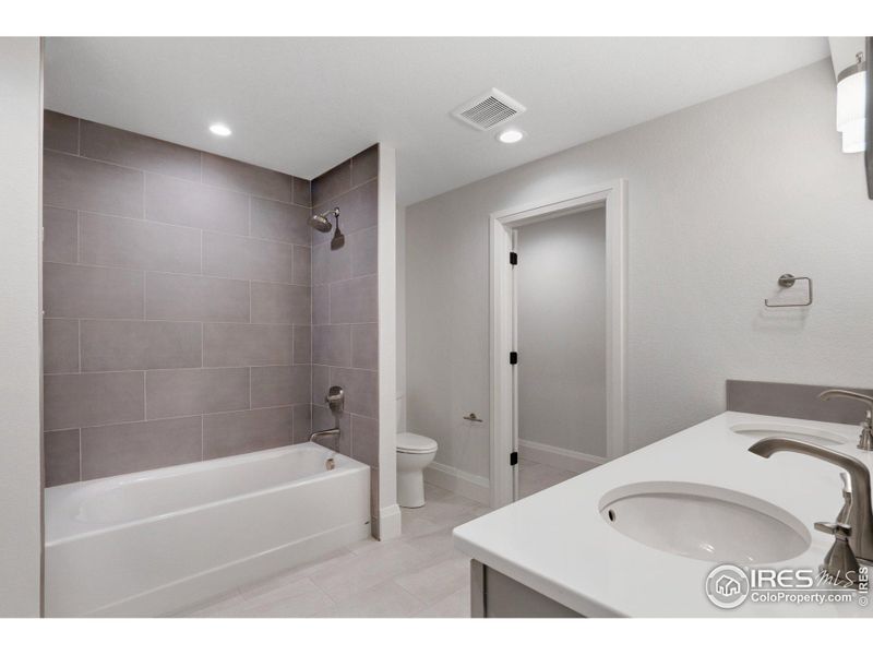 The upstairs full guest bath, which also features full-height tile