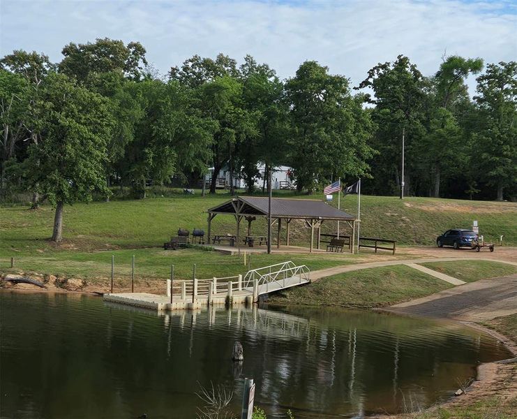 Surrounding community with a water view, a patio, and view of scattered trees