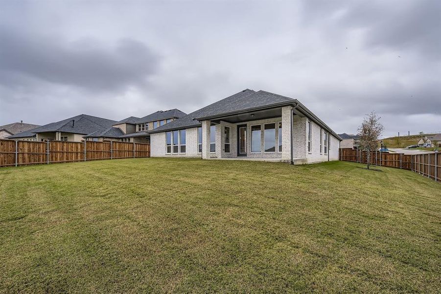 Rear view of property featuring a fenced backyard, a patio area, brick siding, and a shingled roof Rear view of property featuring a fenced backyard, a patio area, brick siding, and a shingled roof