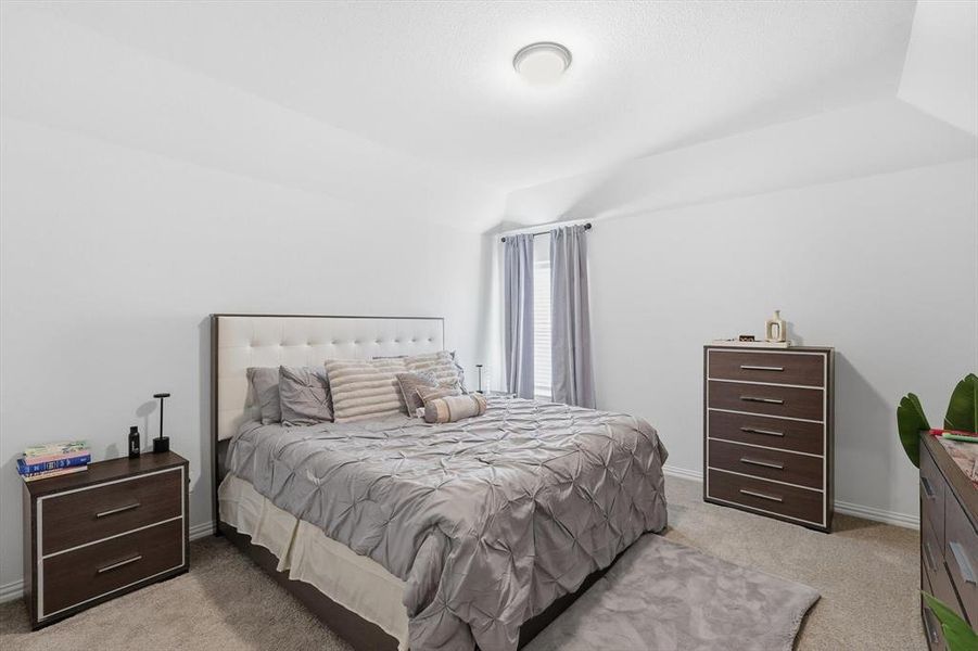 Bedroom featuring light colored carpet and lofted ceiling