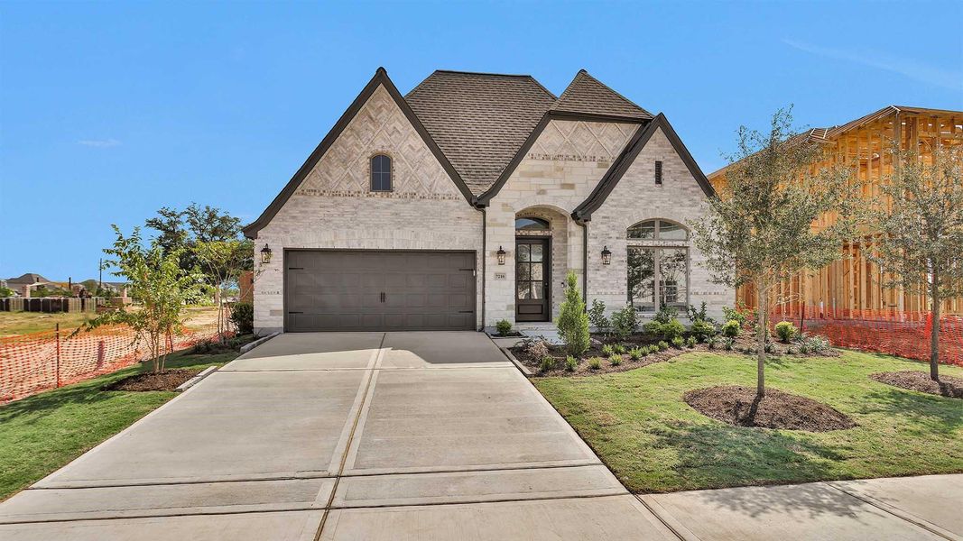 Front exterior of a new home in Elyson 55', Katy, TX, highlighting curb appeal (Image 2). Front exterior of a new home in Elyson 55', Katy, TX, highlighting curb appeal (Image 2).