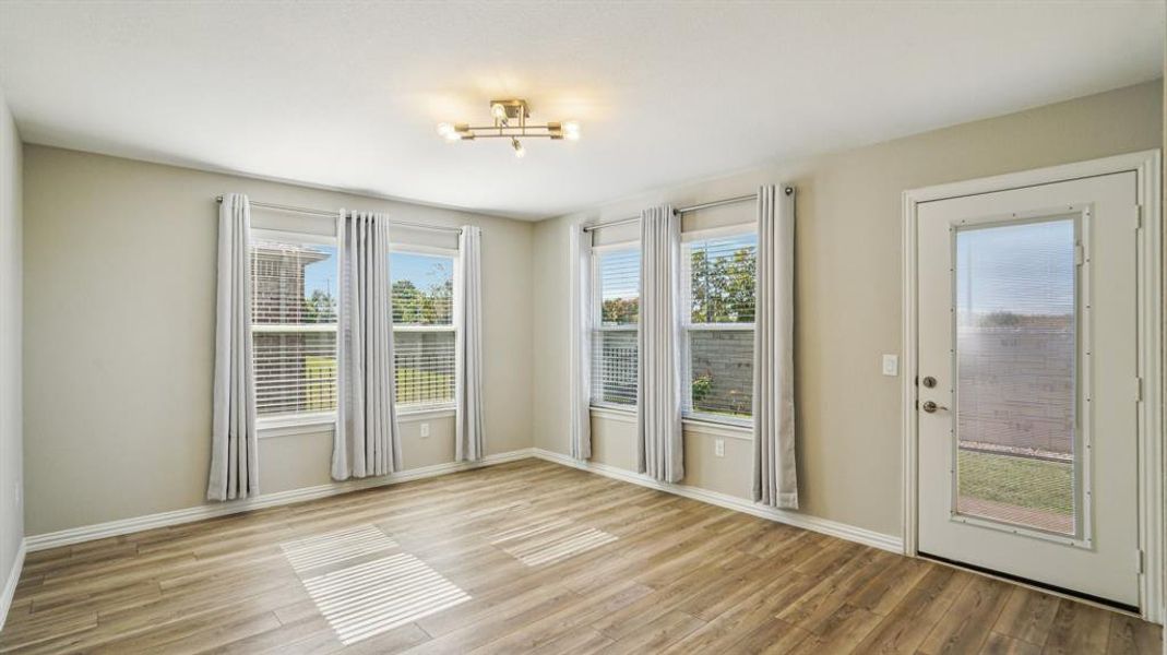 Unfurnished room featuring plenty of natural light and light wood-type flooring Unfurnished room featuring plenty of natural light and light wood-type flooring