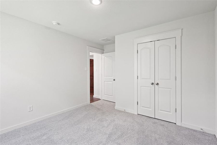 Unfurnished bedroom featuring a closet and light carpet