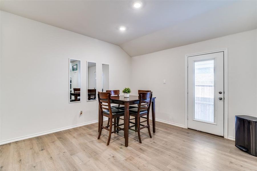 Dining area with vaulted ceiling, light wood finished floors, recessed lighting, and baseboards