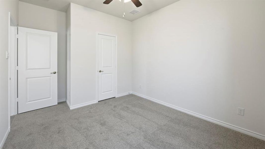 Unfurnished bedroom featuring carpet floors and ceiling fan