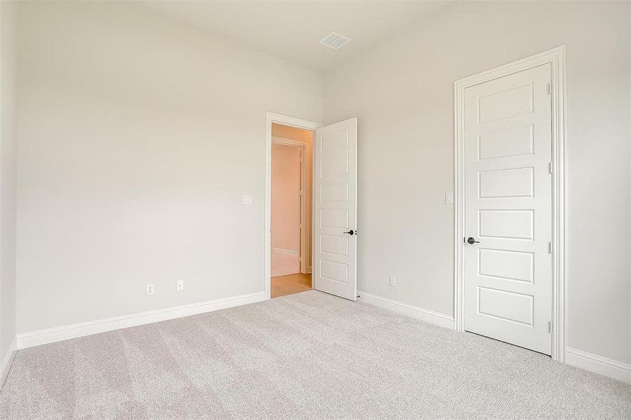 Empty room with light colored carpet