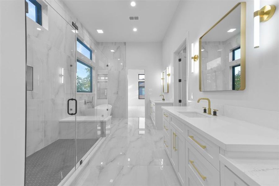 Luxurious ensuite primary bathroom with a walk-in shower featuring a wall of glass and large bench seat, vessel tub, double sinks and seated vanity space create a serene and relaxing environment.