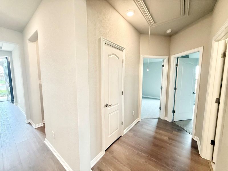 Corridor featuring wood finished floors and attic access Corridor featuring wood finished floors and attic access