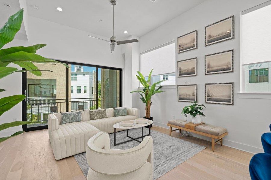 Natural light floods this living space, featuring high ceilings and beautiful hardwood flooring. Natural light floods this living space, featuring high ceilings and beautiful hardwood flooring.