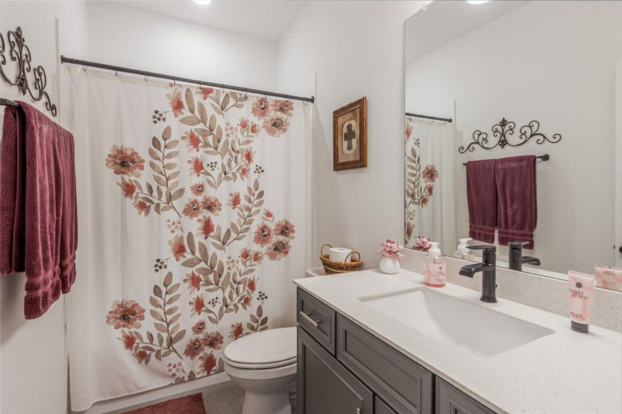 Charming bathroom that features quartz vanity and modern cabinetry and features. This bathroom is located off the hallway as you enter the front door and sits between 2 guest bedrooms.