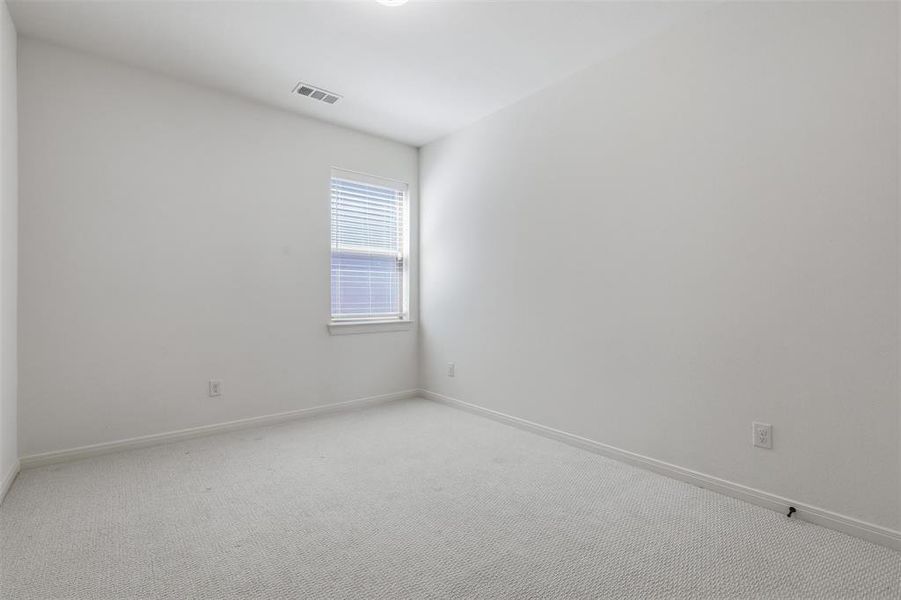 Carpeted interior room with white walls, a single window with blinds, and white trim Carpeted interior room with white walls, a single window with blinds, and white trim