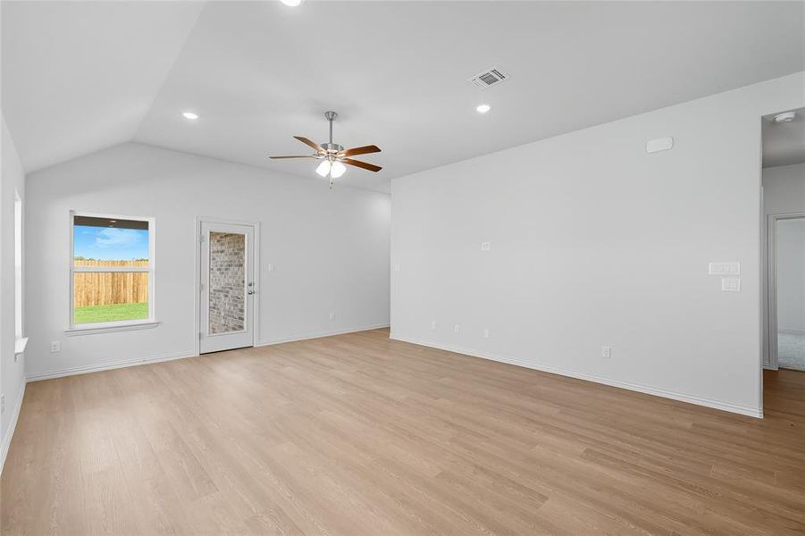 Unfurnished living room with light wood finished floors, vaulted ceiling, recessed lighting, and a ceiling fan Unfurnished living room with light wood finished floors, vaulted ceiling, recessed lighting, and a ceiling fan