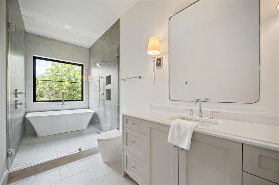 Full bath featuring a soaking tub, vanity, and tile patterned floors
