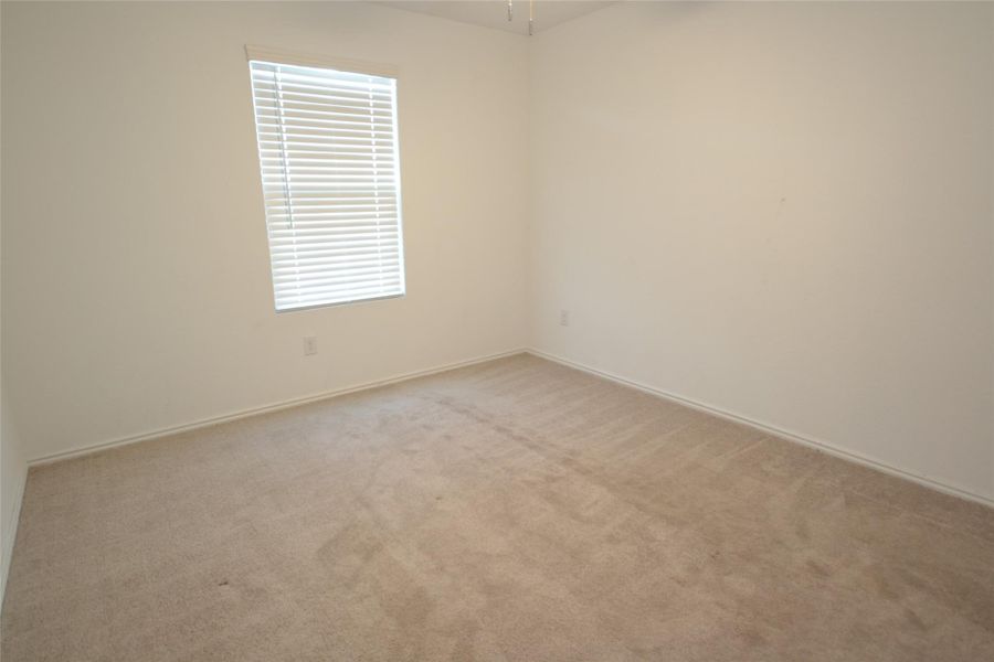 Spare room featuring light carpet and baseboards