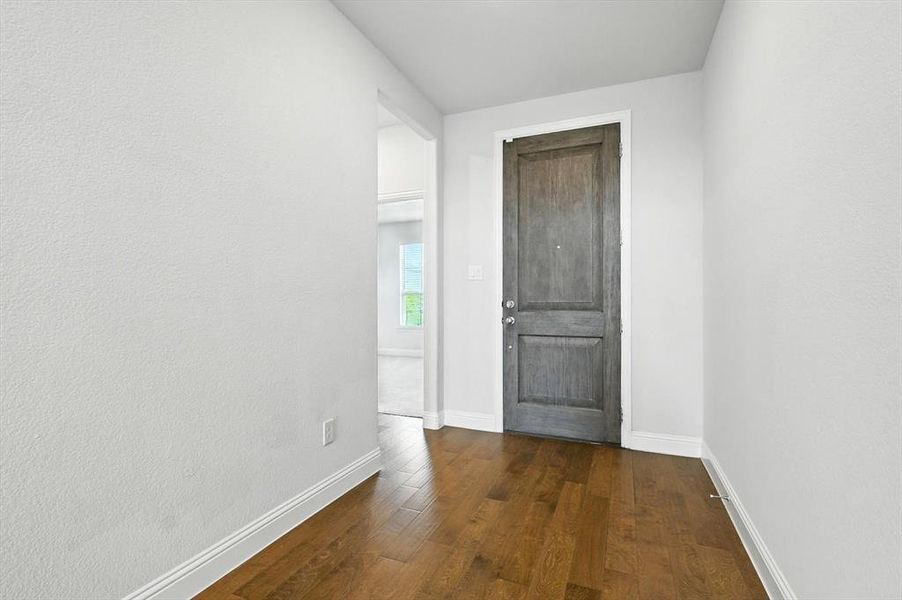 Foyer entrance featuring wood floors and expansive hall.