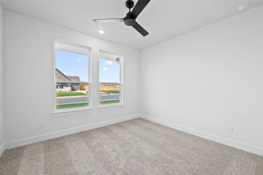 Carpeted spare room featuring baseboards and a ceiling fan Carpeted spare room featuring baseboards and a ceiling fan