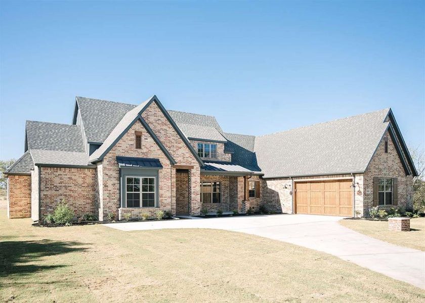 View of front of home featuring a front lawn and a garage