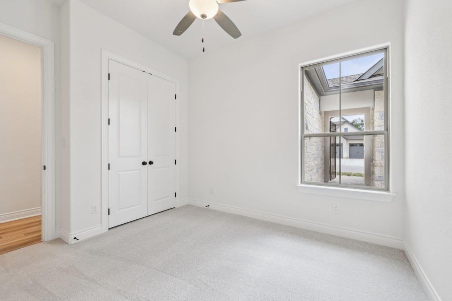 Unfurnished bedroom with light carpet, a ceiling fan, and a closet