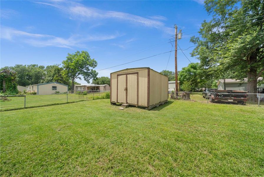 Fenced backyard with a storage shed