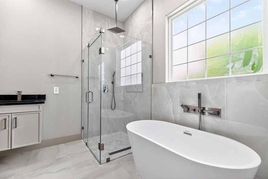 Bathroom with a marble finish shower, vanity, a freestanding bath, and light marble finish floors Bathroom with a marble finish shower, vanity, a freestanding bath, and light marble finish floors