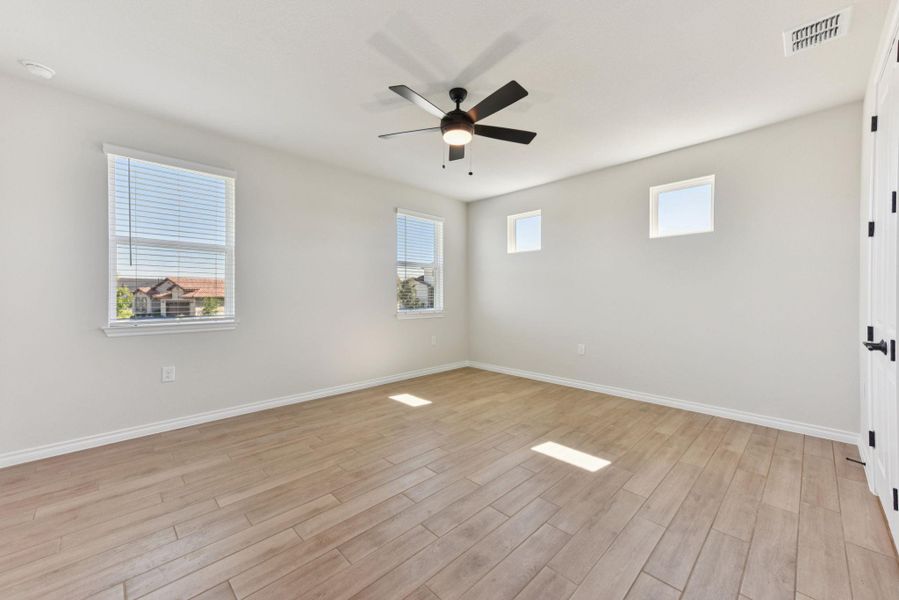 Empty room featuring light wood finished floors and a ceiling fan