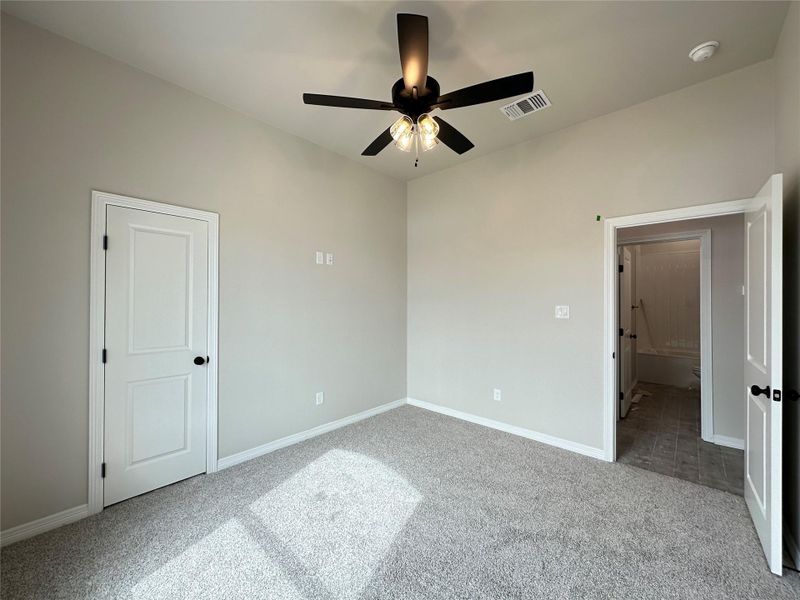 Unfurnished bedroom with light carpet and ceiling fan