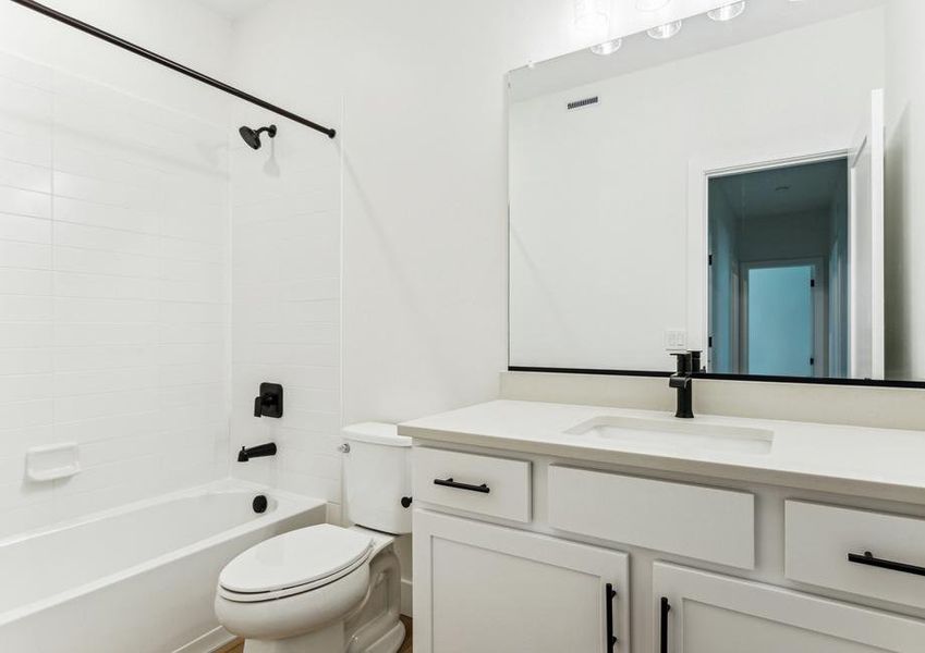 The secondary bathroom has a large vanity space and a shower-tub combo.