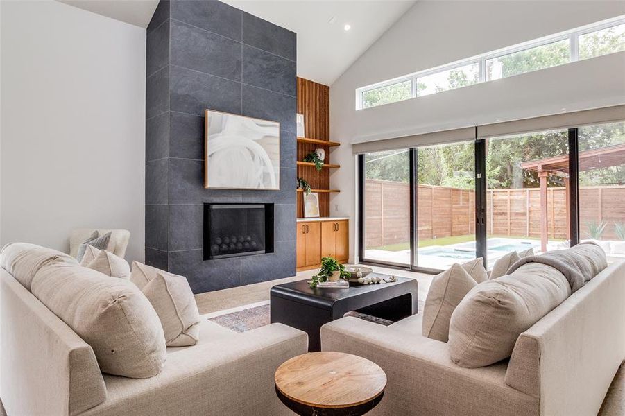 Living room featuring plenty of natural light, tile walls, and a tile fireplace