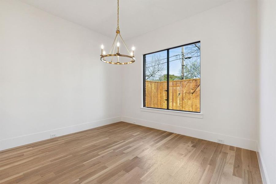 Dining room with an inviting chandelier and hardwood / wood-style flooring