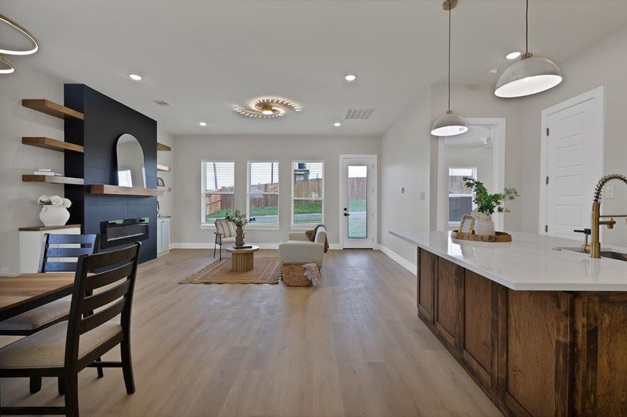 Kitchen featuring light wood-style floors, a sink, baseboards, light countertops, and recessed lighting Kitchen featuring light wood-style floors, a sink, baseboards, light countertops, and recessed lighting