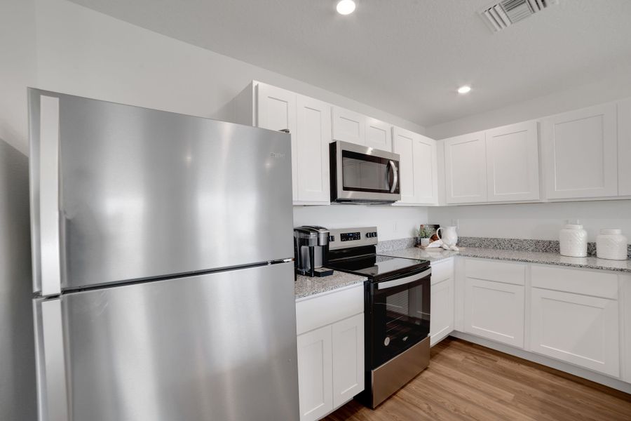 A kitchen with white cabinets.